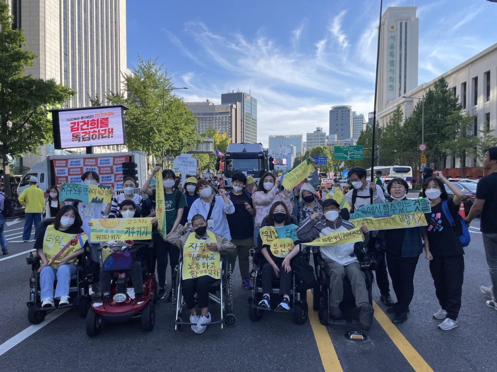 [사진 4] 2022년 923기후정의행진에 참여한 장애여성공감의 단체 사진. 공감에서 만든 피켓과 현수막, 몸자보를 들거나, 입고 있다.