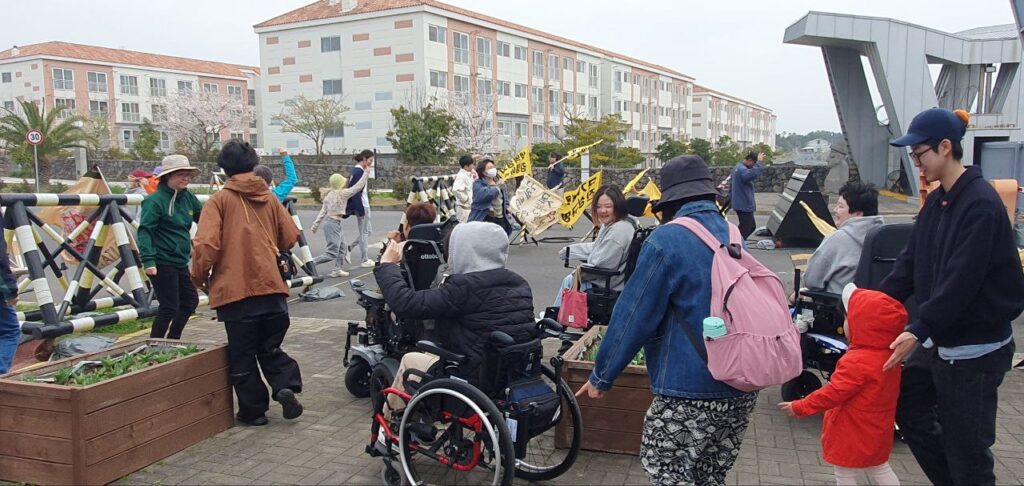 2023.03.31. 장애여성공감 2023 상반기 활동가 워크숍에서 강정마을 해군기지 건설 반대투쟁 인간띠잇기 참여하고 있는 모습. 성별, 장애,연령, 퀴어 등 다양한 몸의 차이를 지닌 활동가들이 해군기지 건설을 반대하는 춤을 추고 있다.