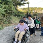 제주도 오르막길에서 전수동휠체어를 밀며 함께 올라가는 모습.