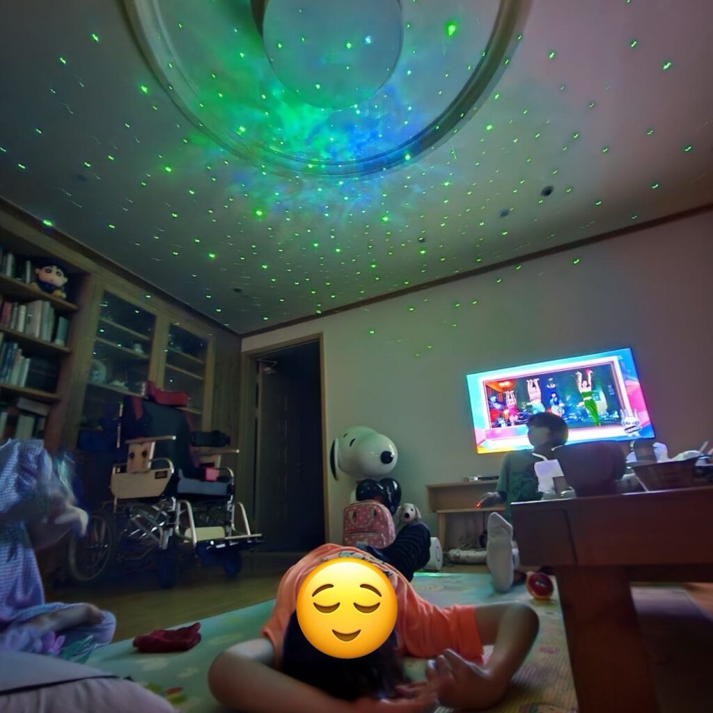 <사진 2. 2023년 거리로나가자 캠프 활동사진. 참여자들이 바닥에 누워 천장을 바라보고 있다. 천장에는 조명이 켜져있다.>